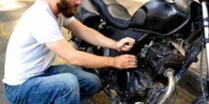 Motard réparant une moto