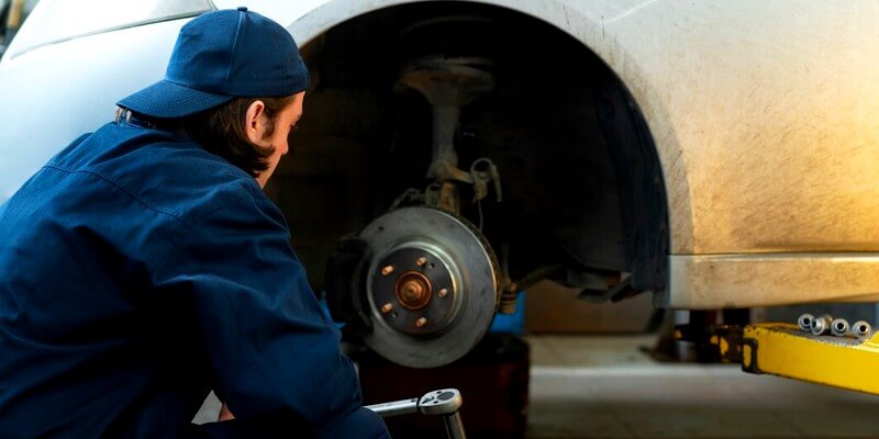 Mécanicien change les disques de frein d'une voiture