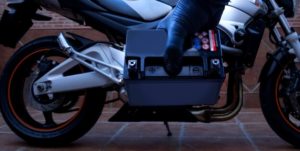 Motard tenant une batterie moto