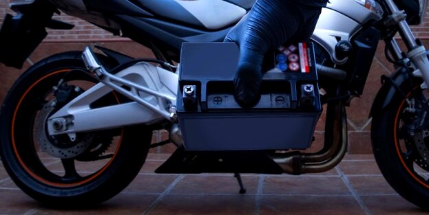 Motard tenant une batterie moto
