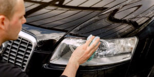 Nettoyer un phare de voiture avec une éponge