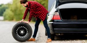 Homme tenant une roue de secours