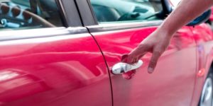 Ouvrir la portière d'une voiture rouge